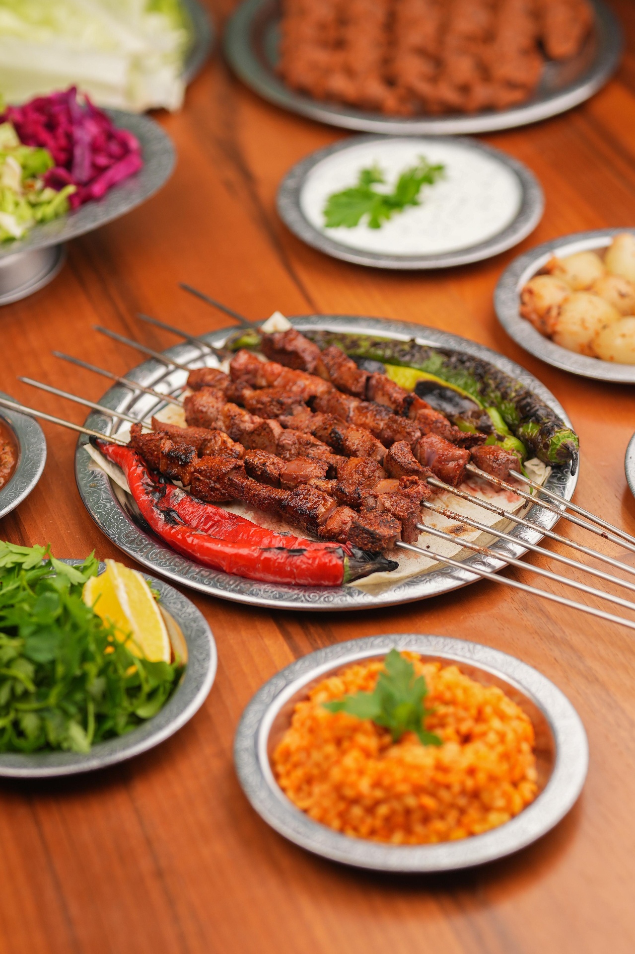 Ciğer şiş, ikramlar ve mezelerle donatılmış ocakbaşı sofrası